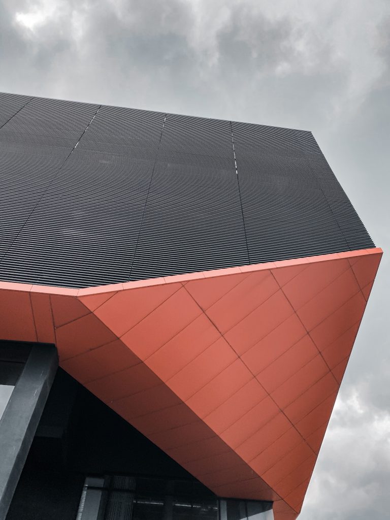 red and black concrete building under white clouds during daytime